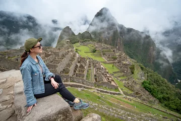 Crédence de cuisine en verre imprimé Machu Picchu Young Asian woman traveler looking at Machu Picchu, one of seven wonders and famous tourist attraction in Cusco Region of Peru. This majestic place has known as 'Lost City of the Incas'