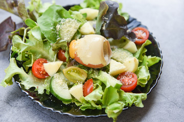Healthy salad vegetable leaves mix salad with fruit and fresh lettuce tomato cucumber and cooked egg on plate on table fresh food eating