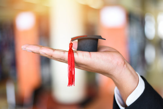 Business man or student with graduation cap on hand in day graduation congratulated the graduates in library at University - Graduation Education Business Study Concept