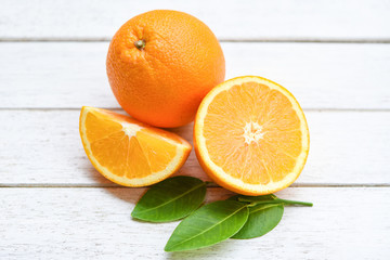Naklejka na ściany i meble Fresh orange slice half and orange leaf healthy fruits harvest concept - Orange fruit on wooden background