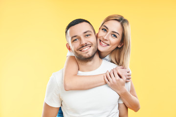Happy smiling couple in love on yellow background