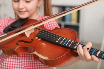 Little girl playing violin at music school