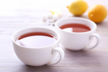 Cups of hot tea on table