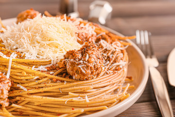 Plate with tasty pasta and cheese on table, closeup