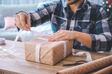 Young man making beautiful gift at home