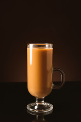 Glass cup of iced coffee on dark background
