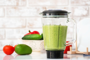 Blender with healthy smoothie on kitchen table
