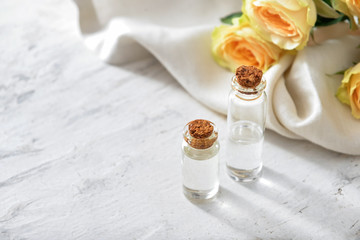 Obraz na płótnie Canvas Bottles of rose essential oil on white background