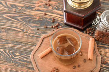 Glass of tasty iced coffee on table