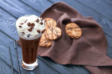 Glass of tasty iced coffee on table