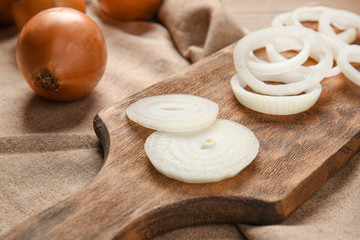 Fototapeta na wymiar Cutting board with fresh raw onion on wooden table, closeup