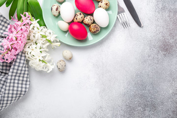 Green mint plate with easter eggs and hyacinths on stone background. Easter concept. Flat lay