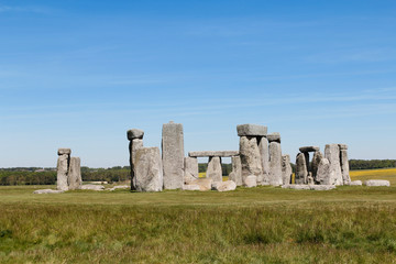View of Stonehenge with green meadow and blue sky on a sunny day in Spring, United Kingdom