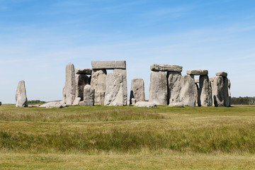 View of Stonehenge with green meadow and blue sky on a sunny day in Spring, United Kingdom