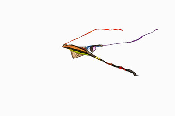 Colored fabric kite with tail in flight with white background 