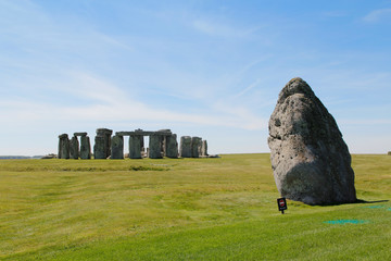 View of Stonehenge with green meadow and blue sky on a sunny day in Spring, United Kingdom