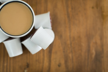 cup of coffee and pods on wooden table - obrazy, fototapety, plakaty