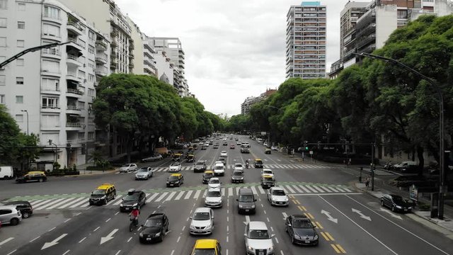 Aerial view of the traffic in Avenida del Libertador in Buenos Aires, Argentina. Drone flying backwards with a cloudy sky as background
