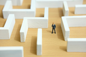 Business strategy conceptual photo - Miniature of businessman looking for solution on a labyrinth...
