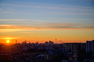 Photo of a morning sunrise in the sky above the city and houses on a clear spring morning