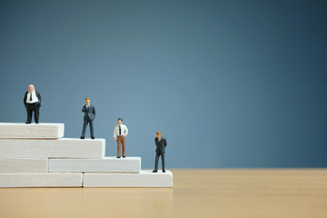 Business strategy conceptual photo - Miniature of businessman stands on a podium