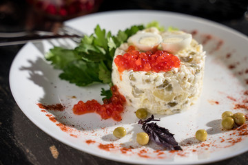 Olivier salad with red caviar from green peas of pickles, restaurant serving, bar serving