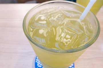 Iced Green tea with a straw on table