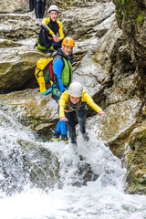 Mutiger Sprung ins schäumende Wasser eines Gebirgsbachs beim Canyoning