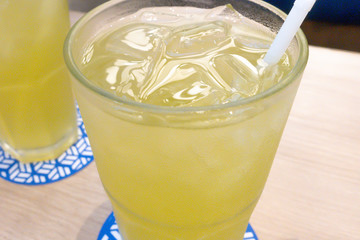 Iced Green tea with a straw on table
