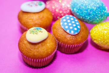 on a pink background close-up of colored Easter eggs and cupcake, holiday background