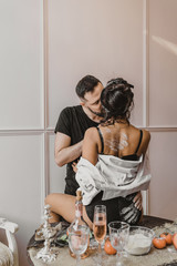 sensual Italian couple stands and kisses in the kitchen Romantic dinner for a young couple in love. Love story. Photo session of lovers in the kitchen