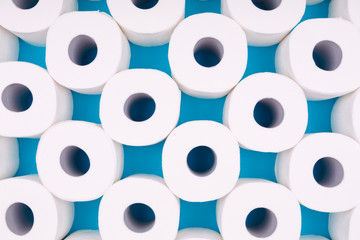 Pattern of toilet paper rolls on the bright blue background. Coronavirus pandemic panic shopping concept. Bright monochrome drop