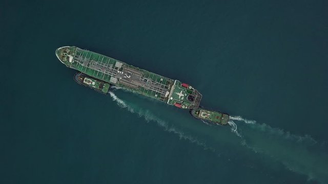 4k, Aerial footage cargo tanker ship vessel at port with marine loading arms platform, Global business oversea commercial trade logistic import export oil and gas petrochemical from refinery industry.