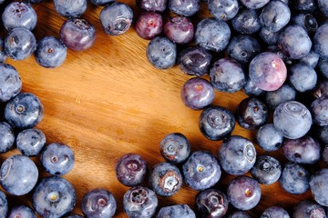 fresh blueberries on wooden table.  Texture blueberry berries. Copy space for your text. top view