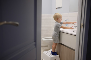 Fototapeta na wymiar kid washing hands in bathroom