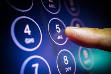 finger entering phone number or passcode on touchscreen numpad. communication, security technology...