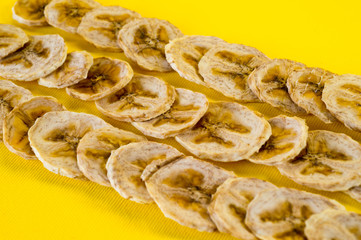 Dried banana chips, sliced in thin circles. Background for healthy and natural nutrition.