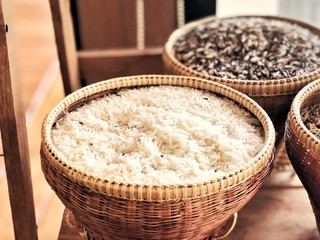 Jasmine rice and rice berry rice in the bamboo baskets, local object of Thai style, Thailand agriculture products. Natural color mode design. Selective focus and blur background.