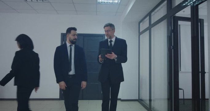 Manager explaining to coworker while walking