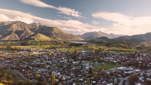 The Beautiful and Peaceful Town Of Arrowtown in the South Island, New Zealand With Different Houses and Rocky Mountain - Aerial Shot