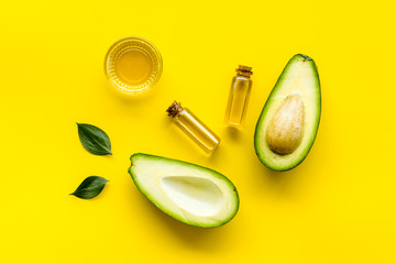 Avocado oil - skin care concept - on yellow background top-down