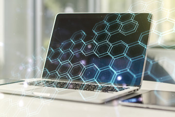 Double exposure of technology hologram with hexagon on laptop background. Research and development...