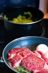 Close up and selective focus of Raw fresh red beef steak and ingredients in frying pan