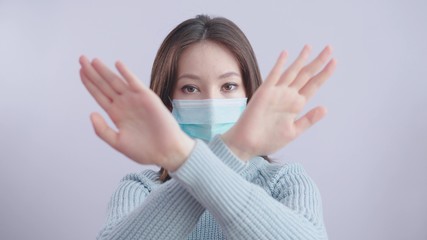 Stop the virus and epidemic diseases. Healthy woman in blue medical protective mask showing gesture stop. Health protection and prevention during flu and infectious outbreak.