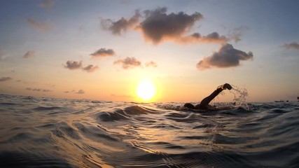 Action cam outdoor follow the Swimmer floating Crawl in Slow Motion in sunset time