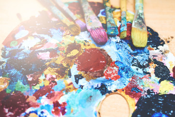 Brushes and paints on a palette, art background