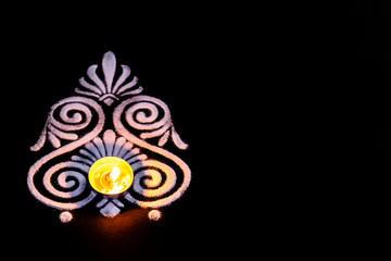 high angle view of beautiful tea lamp and white color rangoli design on balck background with copy space. deepawali concept