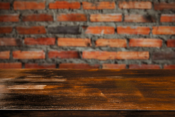 Empty wood table in front of brick wall background