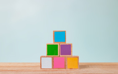 Wooden blocks of many colors arranged on a wooden table, Pastel tones.