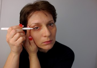 Obraz premium 40 years old woman applying makeup